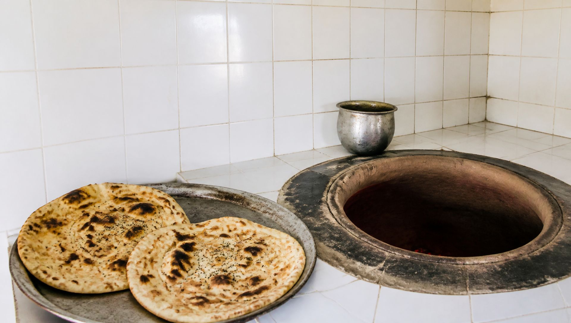 التنور وخبز طازج على الصينية